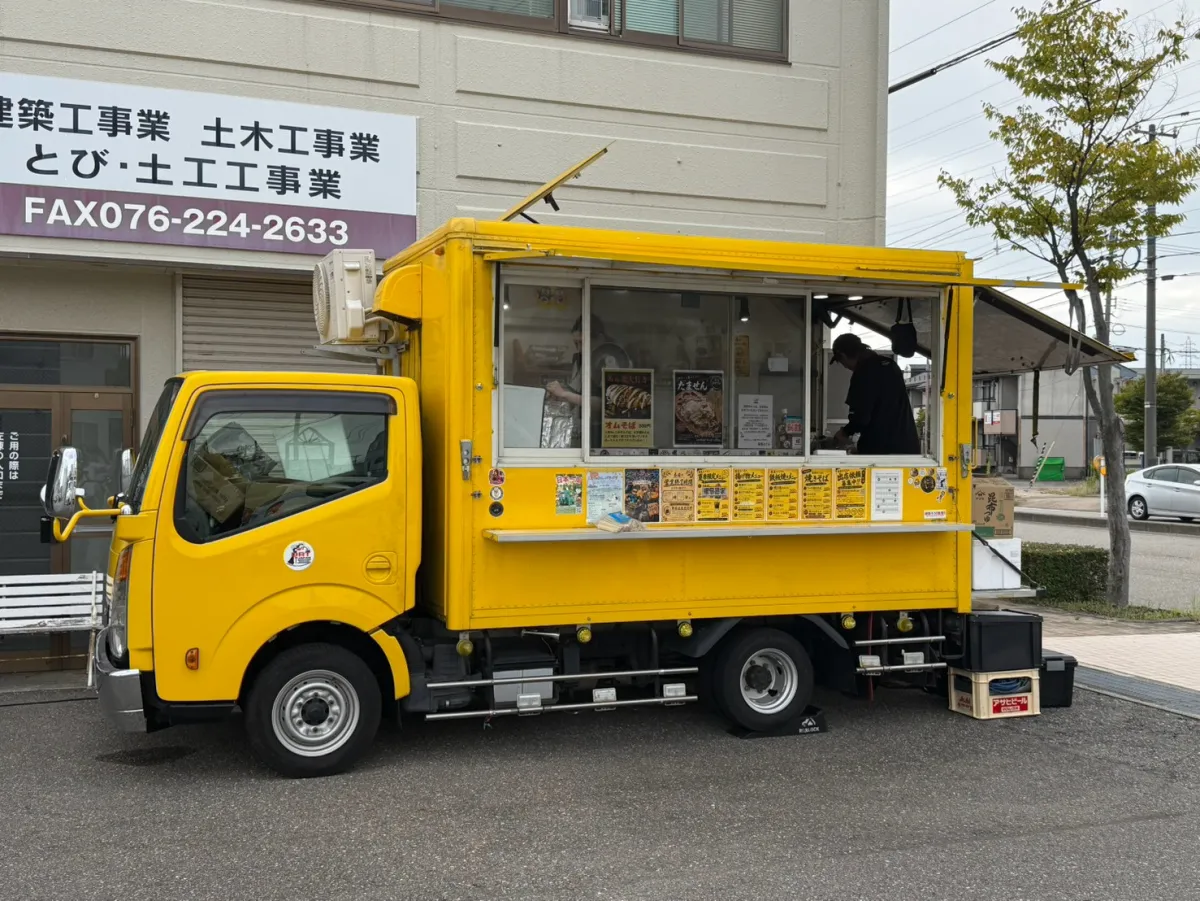 太陽興産の社屋の前に停まった黄色のキッチンカー